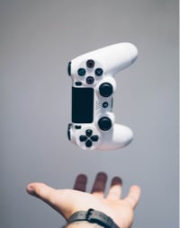 person's hand with a gaming controller floating above it